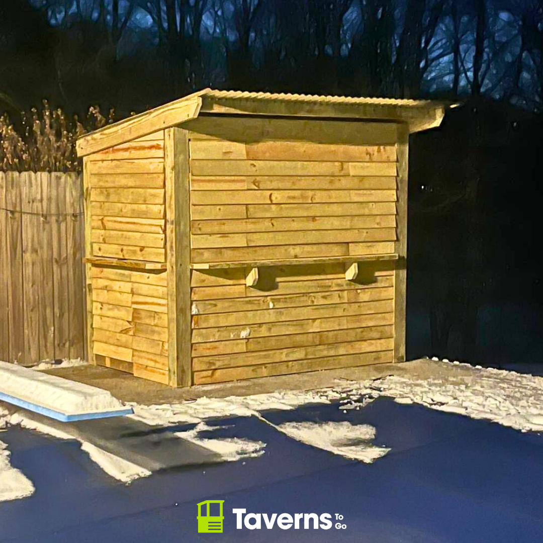 Snow-covered custom patio bar with winter protection covers and winterizing supplies for outdoor entertaining spaces