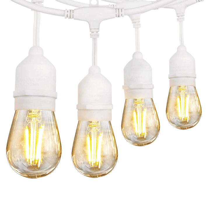 String of four illuminated light bulbs on a white background