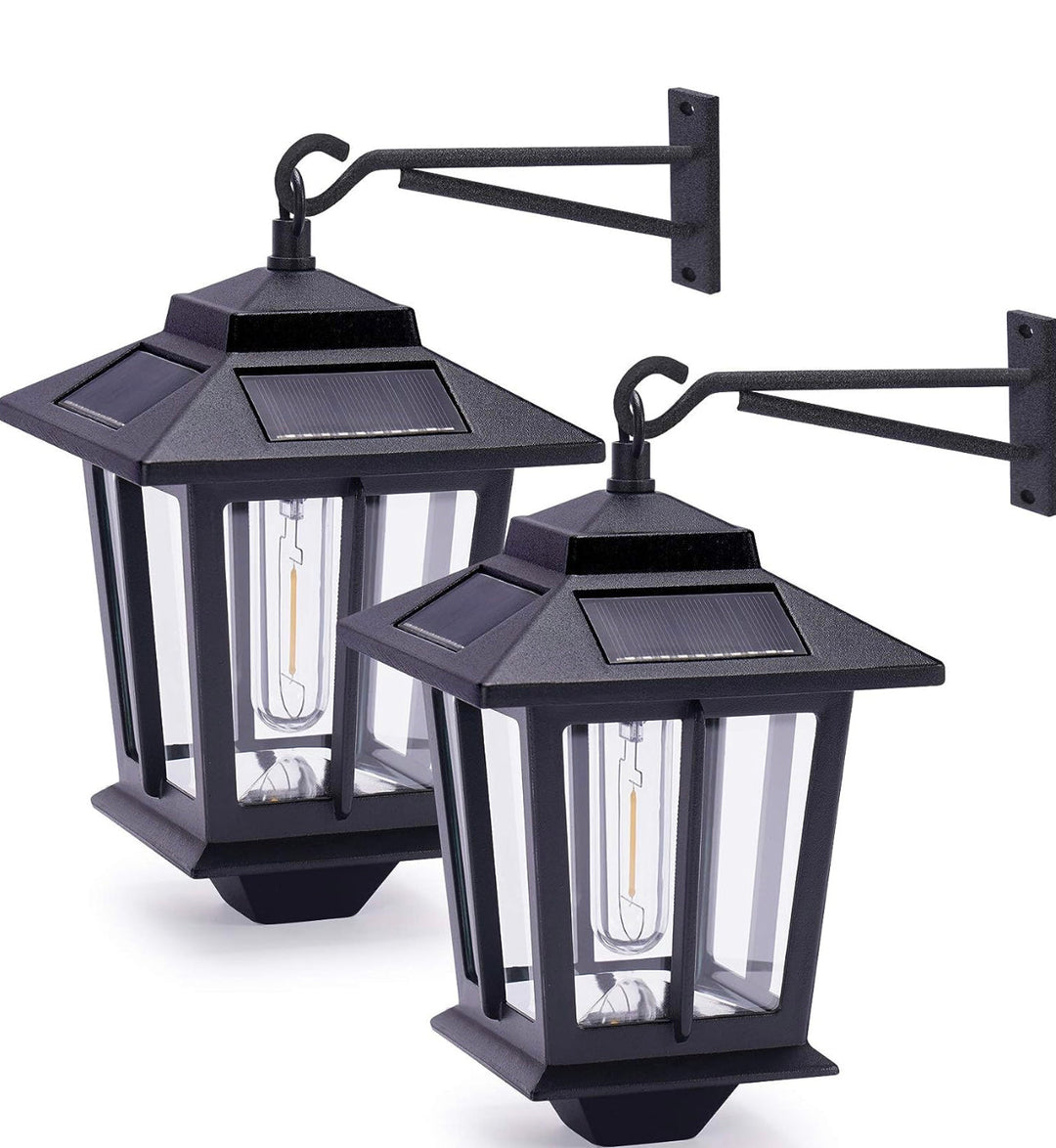 Two black outdoor wall-mounted solar-powered lanterns with glass panels and a mounting arm