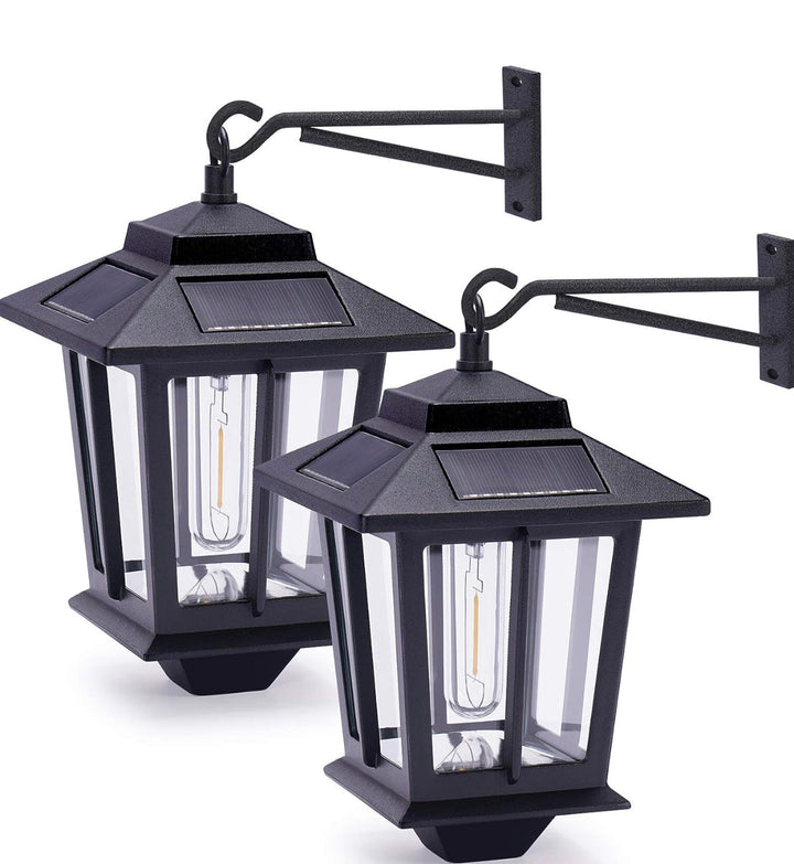 Two black outdoor wall-mounted solar-powered lanterns with glass panels and a mounting arm