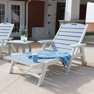 White outdoor lounge chair with a small table and decorative items on a patio.