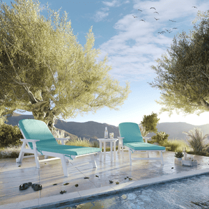 Two turquoise lounge chairs by a pool with trees and mountains in the background