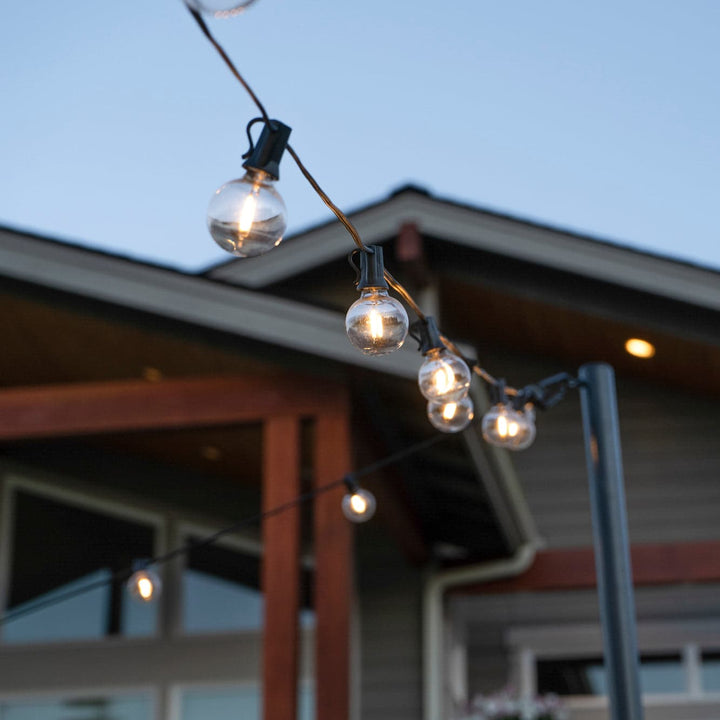 String of outdoor lights hanging against a house backdrop
