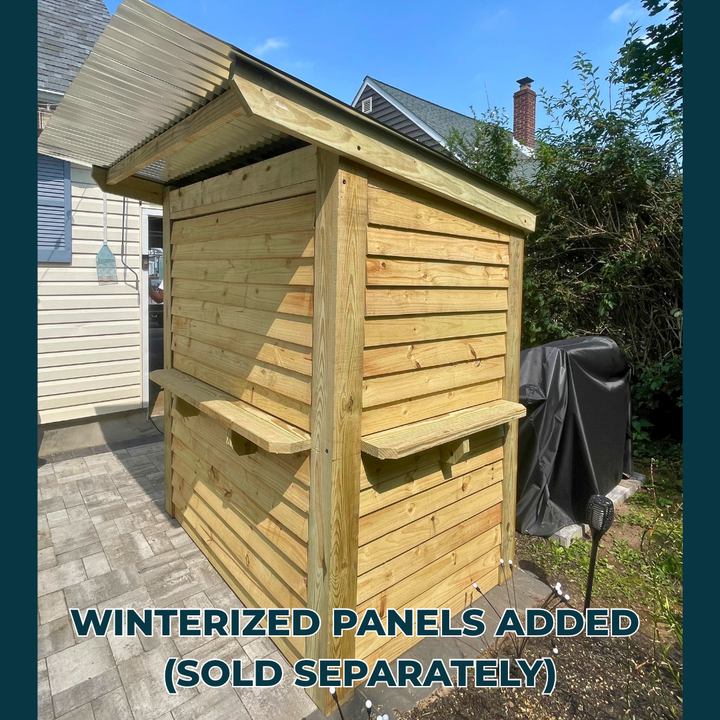 Wooden shed with winterized panels added, outdoors on a clear day.