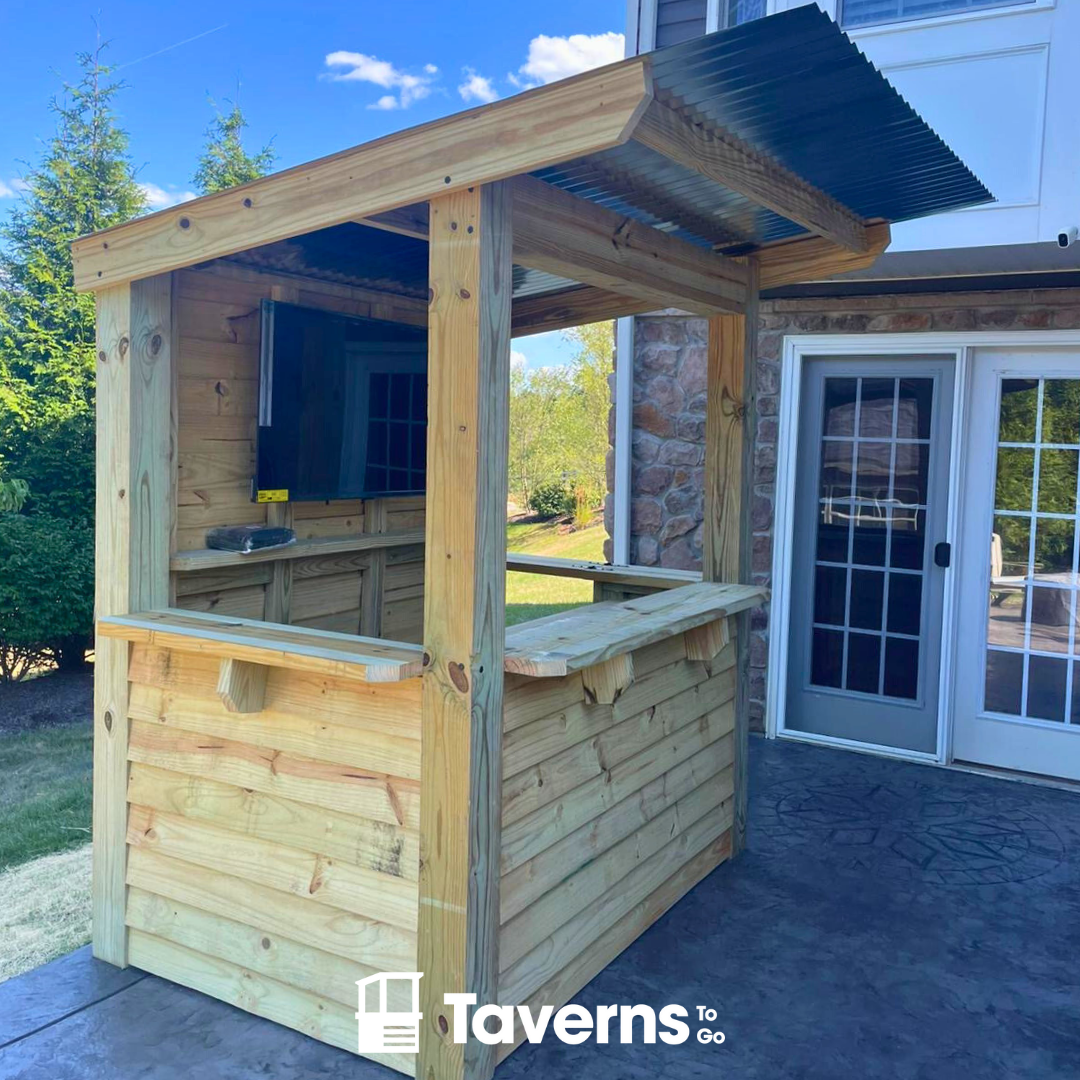 Wooden outdoor bar with a canopy on a patio, featuring the &